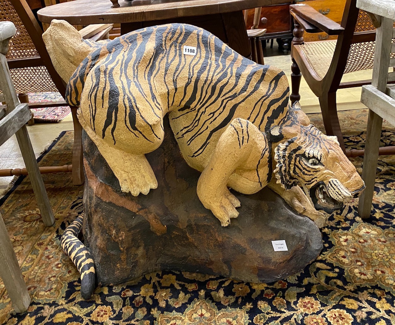 A painted stone garden ornament of a crouching tiger, tail detached, height 75cm